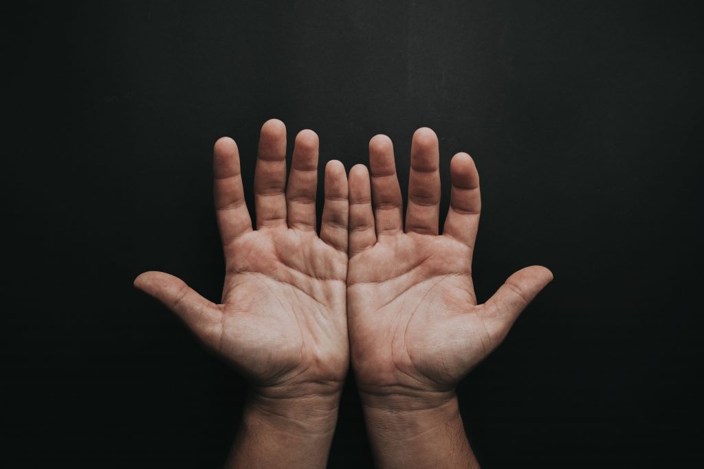 pexels-photo-2258248-2258248 A pair of upturned hands displayed against a dark background, showcasing skin texture.